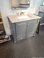 Front view of vanity showing gray cabinet, quartz top, sink, faucet