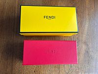 Yellow Fendi outer box closed, red case closed on table