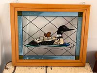 Full view of framed acrylic suncatcher showing loon with chick artwork