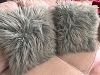 Both shaggy dusty blue pillows on sofa