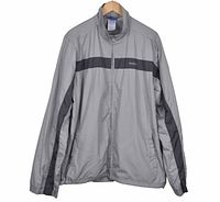 Front view of Reebok gray windbreaker showing stripe, zipper, pockets, collar