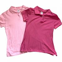 Front view of both polo shirts showing colors, buttons, collars, and overall condition