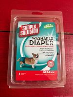 Front of retail packaging showing brand, product type, image of dog wearing diaper