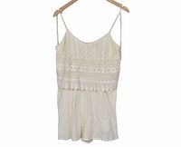 Front view of ivory crochet lace romper hanging on hanger
