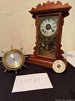 Mantel clock, ship-wheel thermometer and round barometer grouped together
