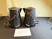 Front view of both speckled enamel coffee pots with lids and handles