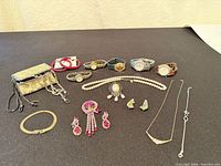 All items laid out showing watches, purse, jewelry pieces