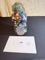 Jar filled with multicolor marbles, full lot view