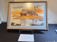 full view of framed watercolor painting on stand