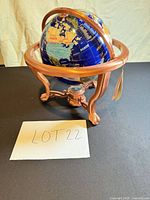 Full view of blue gemstone globe on copper-tone metal stand