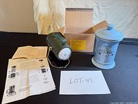 Full lot view with lantern, ceramic jar, box, and paperwork