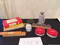 overall lot showing cookbooks, pastry press, cutters, ceramic jar, slide rule, ruler, straps