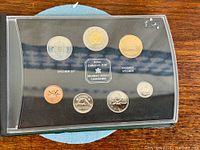 Front view of sealed 7-coin specimen set in RCM holder