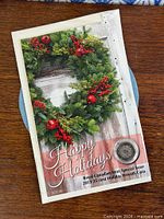 Front of greeting card showing Happy Holidays design and encapsulated coin