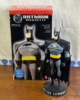 Front view of Batman statue in front of box