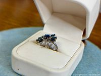 Ring in presentation box showing cluster setting and stone arrangement