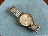 Front view showing dial, bracelet, branding, day/date window