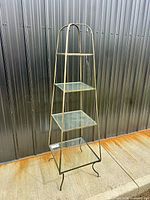 Full view of etagere showing frame, four glass shelves and feet