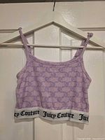 Front view of lavender Juicy Couture crop tank top on hanger