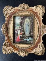 Front view of illuminated Virgin Mary glass picture in ornate frame