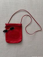 Front view red Carlos Falchi purse with sunglasses