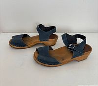 Pair of blue leather wood-sole clog sandals, side view