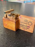 Wood box with lid removed showing wooden alphabet stamps
