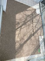 Large and small beige rugs on tile floor