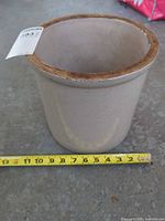 Full view of crock with measuring tape, showing size and rim discoloration