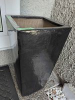 Gloss black rectangular tall planter showing exterior glaze and interior clay.