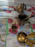 Group shot showing both mortars with pestles, nested measuring cups and bell with bracket