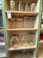 Full shelf view showing majority of the 14 glass jars and canisters