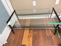 Full view of glass top coffee table showing top and two lower glass shelves