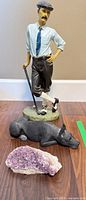 Golfer figurine, dog statue, and amethyst geode grouped together