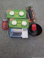 all items group shot: two Camp Heat boxes, pan with brush, boxed radio, red flashlight