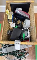Basket containing all lot items including blood pressure monitor, fan, cords and power strip