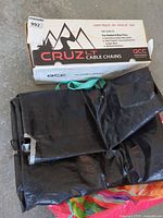 Boxed QCC Cruz LT cable chains beside folded black tarp