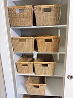 Seven matching seagrass baskets on shelving