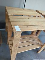 Front view of two-tier solid wood shelf showing natural finish and slatted construction