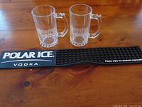 Both MWHL mugs and Polar Ice bar mat on table