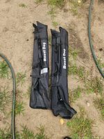 Two black Mount Dog carry bags holding support stand kits