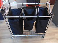 Front view of chrome frame sorter with three black bags on casters