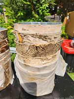 stack of birch bark wrapped metal planters showing exterior texture and interior liner