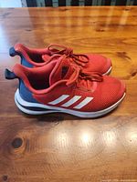 Left side view of both red Adidas FortaRun shoes