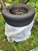 Tire stacked on rusted steel rim showing overall condition