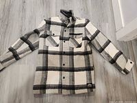 Front view of plaid sherpa-lined shacket laid flat