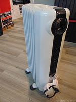 Full view of DeLonghi oil-filled heater showing control panel and wheels