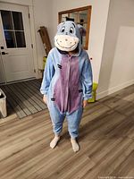 Front view of Eeyore fleece onesie worn, showing hood with face, purple belly, zipper
