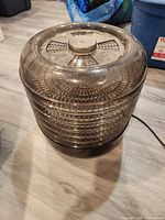 Full view of dehydrator showing lid, stacked trays, base, cord