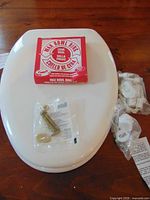 Overall lot with toilet seat, wax ring box, brass bolt kit, plastic hinge kit
